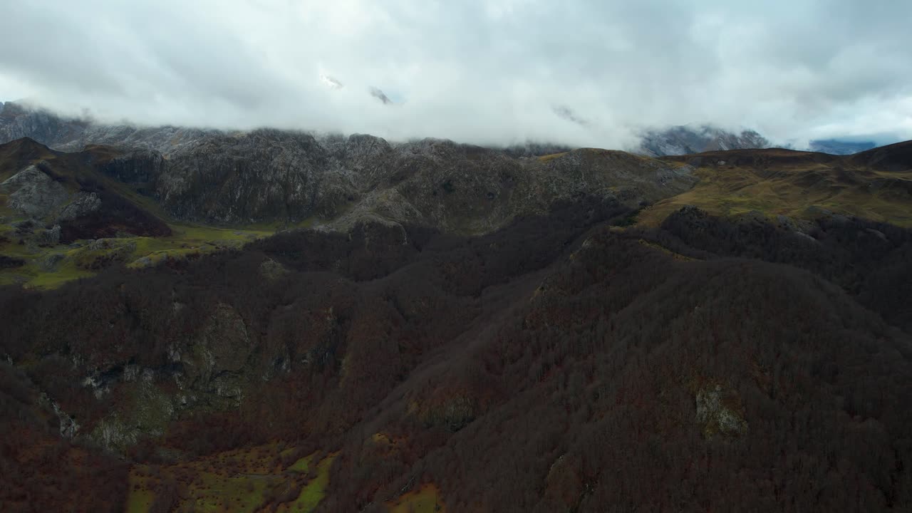 día lluvioso de otoño en las montañas de los alpes albaneses con pico alto rocoso cubierto de nubes y niebla