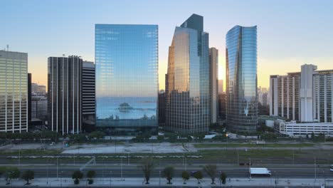 Aerial-of-Puerto-Madero-window-glass-skyscrapers-near-Paseo-del-Bajo-highway-at-golden-hour,-Buenos-Aires