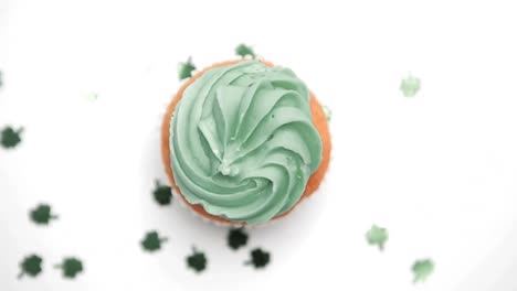 St-patricks-day-cupcake-turning-with-green-shamrock-confetti-falling
