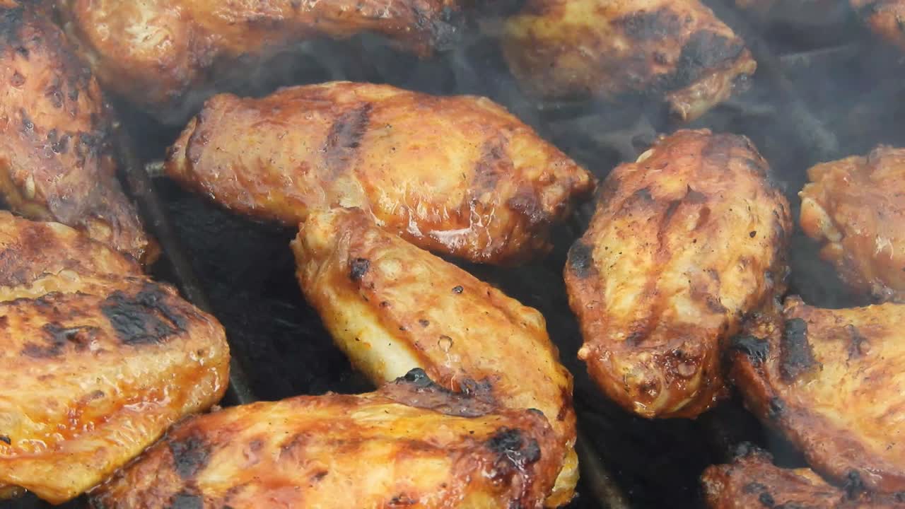 Outdoor grill with chicken wings, pork and fish under the heat of flames and smoke with nice texture and appetizing look.