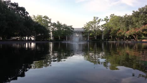 fuentes encendidas en la piscina reflectante frente a un edificio durante el día