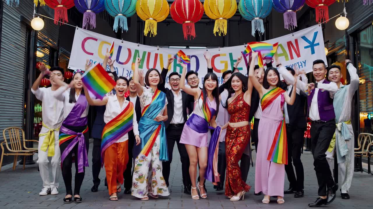低角度拍攝的熱鬧街頭節慶影片，一群人身穿繽紛服飾，展現歡樂氣氛。