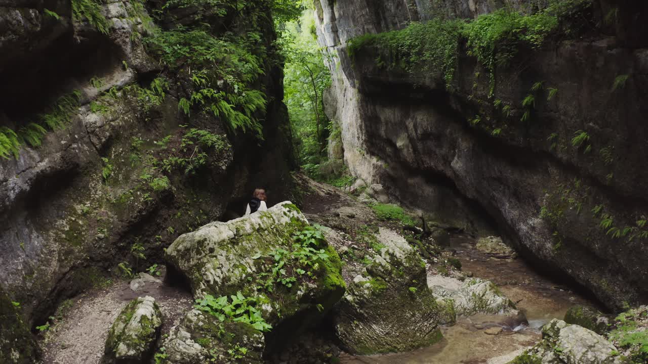 mujer caminando a través de un cañón rocoso