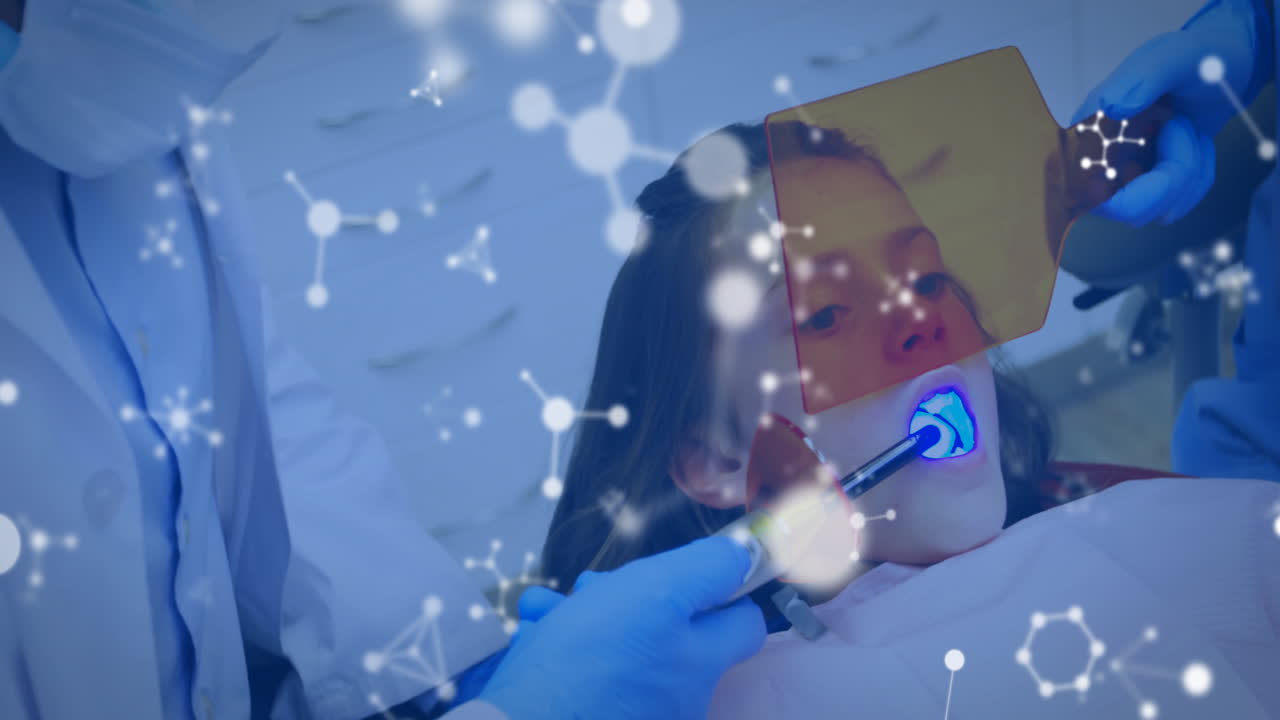 Animation of molecules over caucasian male dentist and girl patient