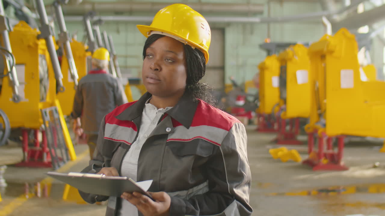 African American Woman in Hardhat Working in Machinery Plant