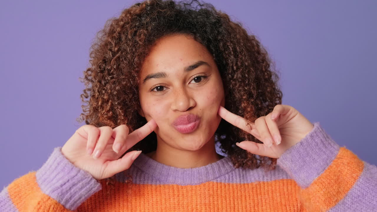 Playful Young Woman with Curly Hair Making Cute Facial Expressions