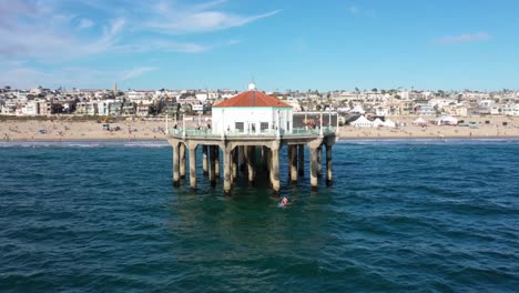 Muelle-De-La-Playa-Del-Océano-Pacífico-En-California,-Estados-Unidos-Con-Surfista-En-El-Agua