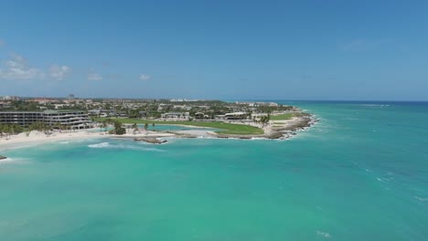 aerial coastal of beach and golf course surrounded by turquoise water and resort property, establishing
