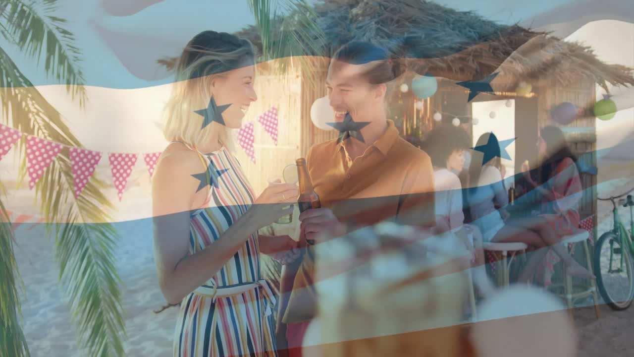 At beach party, couple holding drinks with animation of Honduras flag