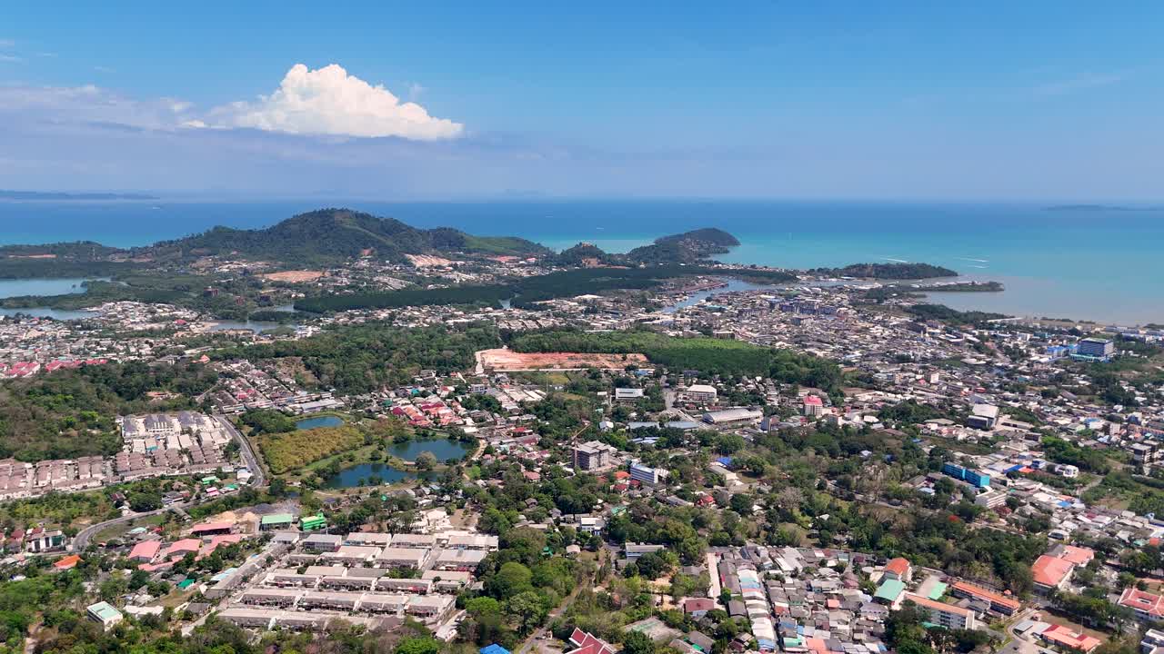 드론 영상은 푸켓의 울창한 풍경과 활기찬 해안선을 은 하늘 아래 포착하여 도시와 자연의 아름다움을 강조합니다.