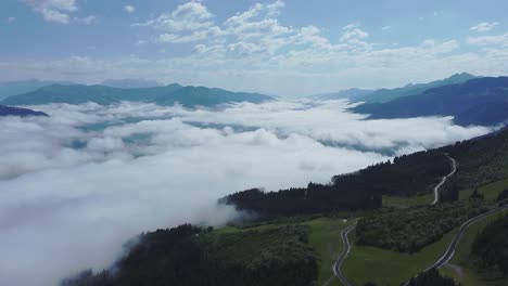 drone flight above low hanging clouds blanketing a valley in austria