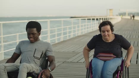 happy couple using wheelchairs racing on bridge