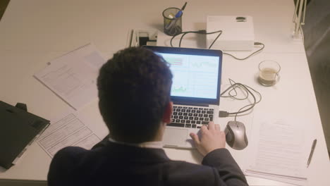 caucasian bearded man working in office while typing on laptop