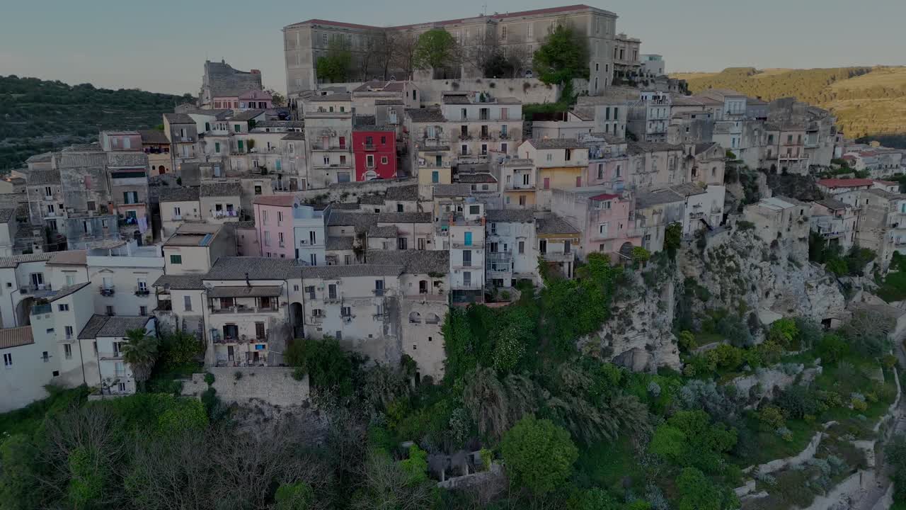 A drone flights horizontally on Ragusa Ibla side revealing the city edges over the hills