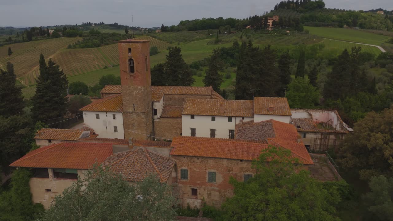 Cinematic drone flyby of a historic stone tower in Tuscany, Italy. Surrounded by vineyards, cypress trees and rustic buildings, this shot captures the charm of rural Italian architecture.