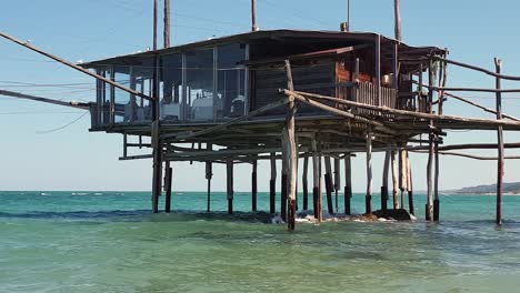 Panning-of-romantic-sea-restaurant-inside-traditional-Italian-trabocco-or-trabucco