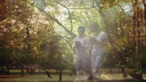 animación de madre y hija asiáticas felices caminando y bebiendo té sobre las hojas que caen