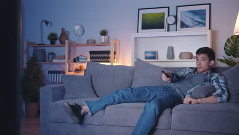 man watching tv on couch at night