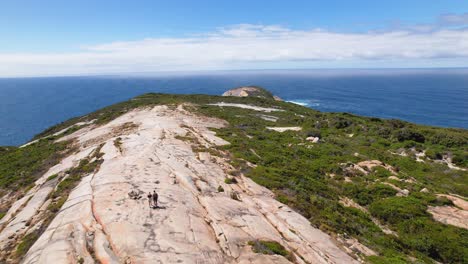 Video-De-Drones-De-4k-Sobrevolando-A-Dos-Personas-Recorriendo-El-Sendero-Para-Caminar-Con-Cabeza-Calva-Dentro-Del-Parque-Nacional-Tordirrup-En-Albany,-Australia-Occidental