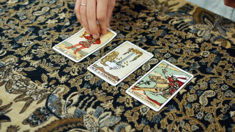 a woman giving a tarot reading with the page of cups the ace of swords and the knight of swords cards