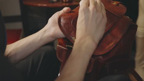 spreading wax using white sponge on the flap of a leather bag