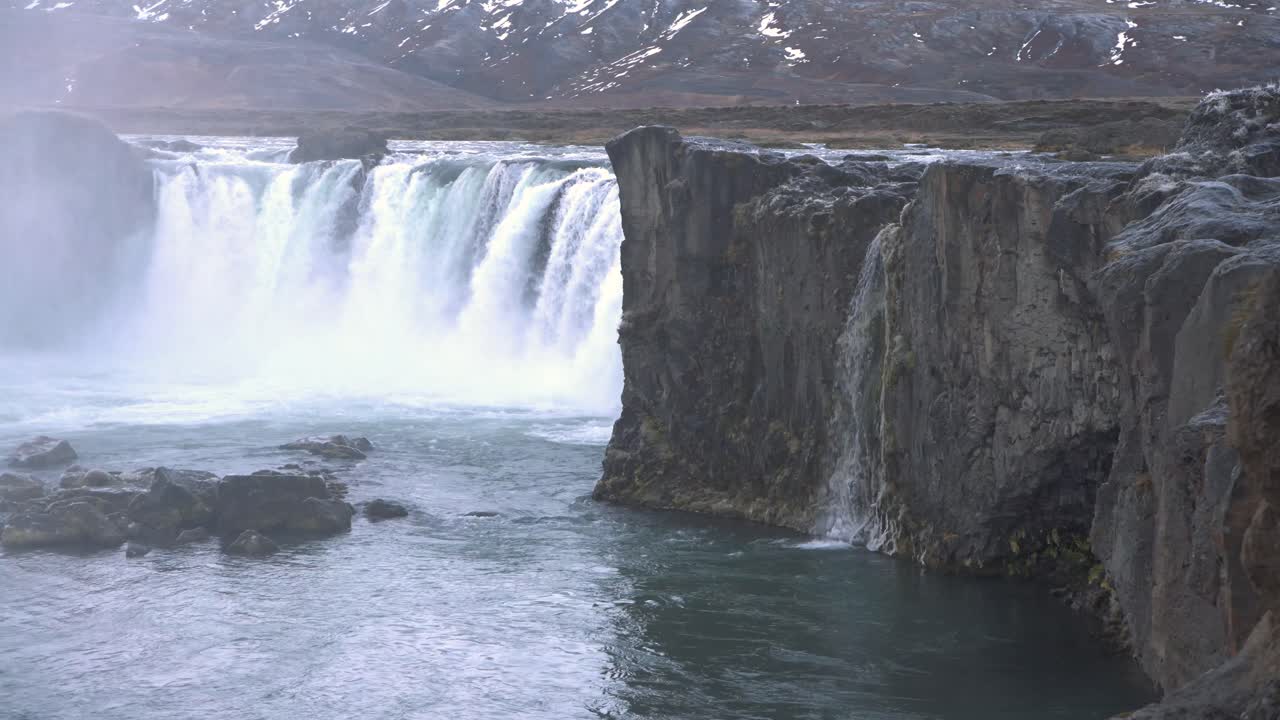 acantilados rocosos y el lago de la rugiente cascada de godafoss en islandia