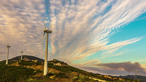 paisaje de lapso de tiempo de molinos de viento fuente de energía renovable en el campo colinas montañas y horizonte soleado, nubes movimiento de paso