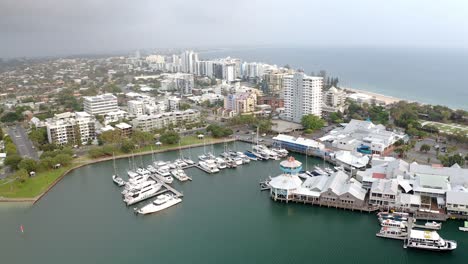 Vista-Aérea-De-Yates-De-Lujo-Y-Barcos-Amarrados-En-El-Embarcadero-Del-Río-Mooloolaba-Con-Restaurante-De-Mariscos-Y-Hoteles-Frente-Al-Mar-En-Qld,-Australia