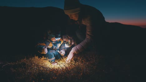 hike in arctic at night. mother hikes with her toddler daughter in the arctic area and search berries with torch