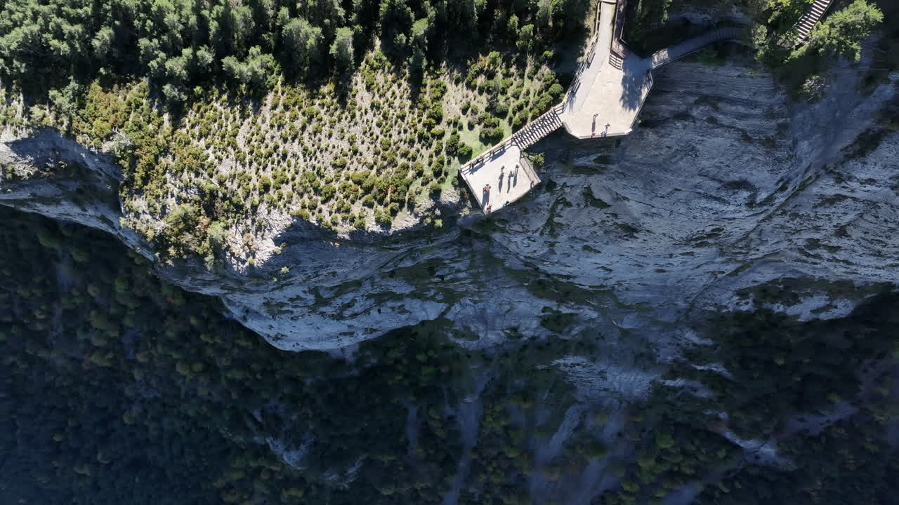 vista aérea volando sobre los turistas de turismo en la plataforma de observación del acantilado con vistas al pintoresco bosque de montaña de cataluña