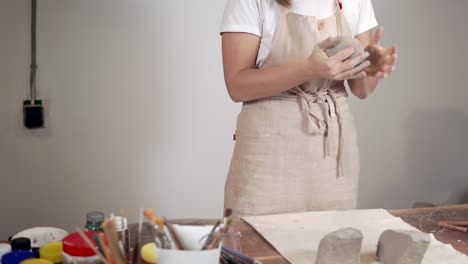 woman shaping clay in pottery studio