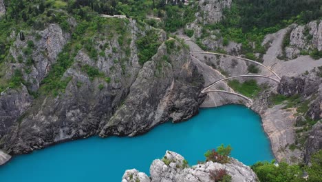 antena en movimiento hacia adelante sobre los altos acantilados rocosos que rodean el lago azul en el sumidero en imotski, croacia