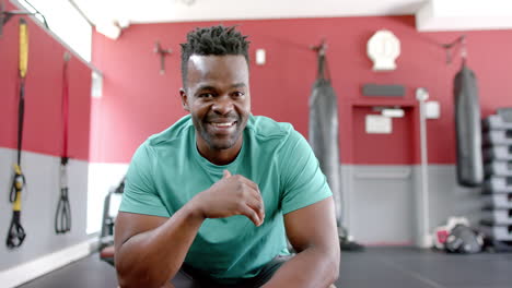 hombre afroamericano en forma sonriendo en un gimnasio