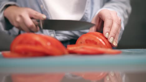 Vorderansicht-Der-Hände-Einer-Frau,-Die-In-Zeitlupe-Frische-Rote-Tomaten-Auf-Einem-Schneidebrett-In-Scheiben-Schneidet.-Nahaufnahme-Der-Hände-Einer-Frau-Mit-Beigem