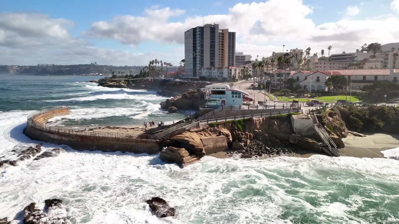 Sharp midday visuals of breaking waves at the Children's pool in La Jolla San Diego CA a rugged shoreline