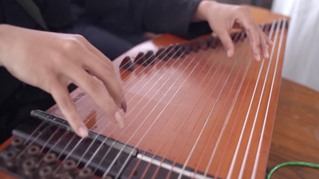 Close-up of a Person Playing a Traditional Indonesian Zither