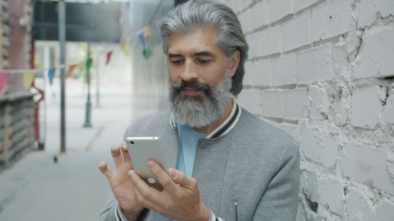 Older Man Using Smartphone in Urban Alley