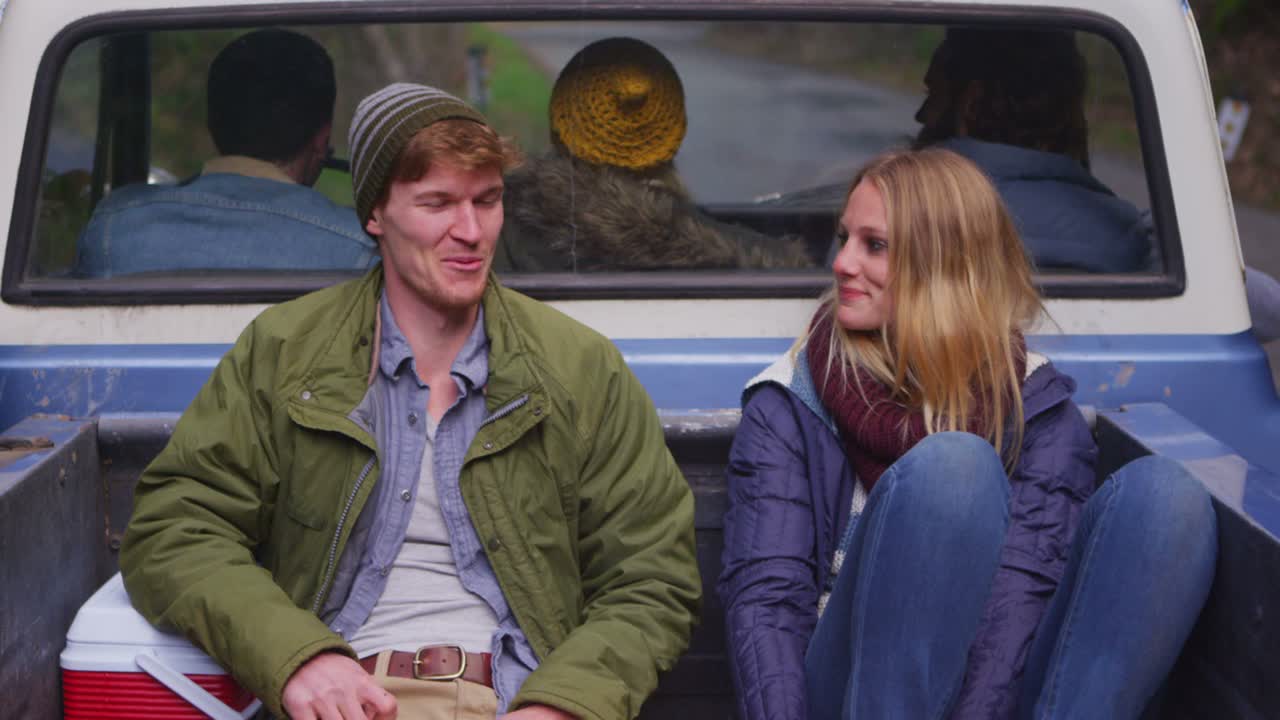 una pareja se sienta en la parte trasera de una camioneta mientras se aleja 1