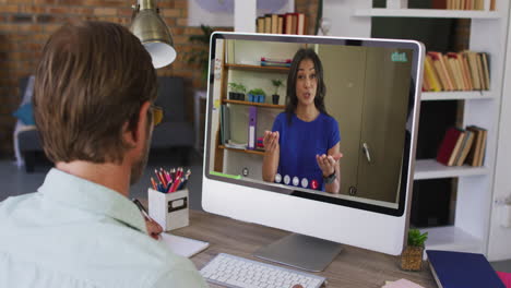 profesor caucásico que tiene una videollamada con una colega en la computadora de la escuela