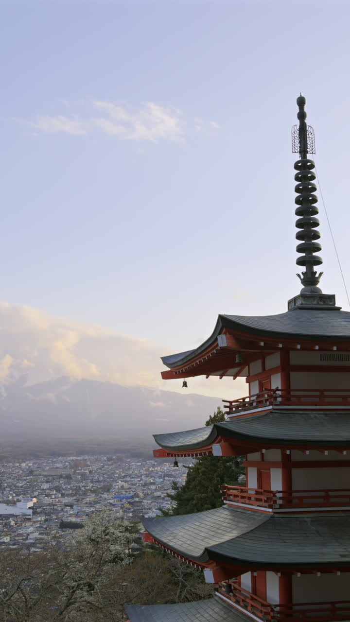 Esplora la bellezza della pagoda Chureito che si affaccia su Fujiyoshida in incantevoli tonalità del tramonto con una vista panoramica sul paesaggio urbano