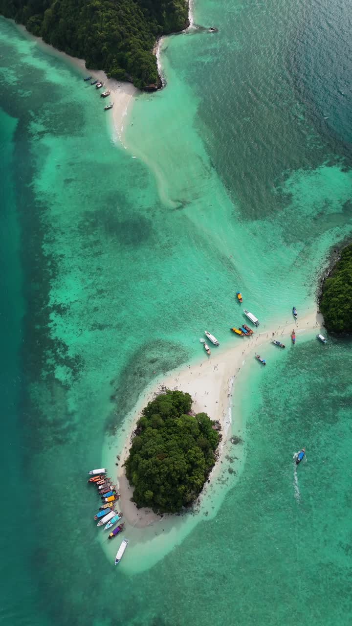 Vertical drone begins top-down above turquoise waters and tilts up to reveal Thale Waek and Kok Hua Kuan Islands connected by a sandbar in Krabi