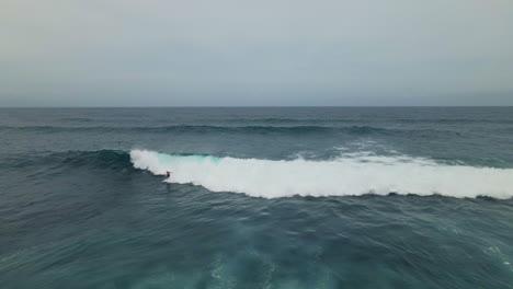 High-angle-aerial-view-of-surfers-riding-ocean-wave