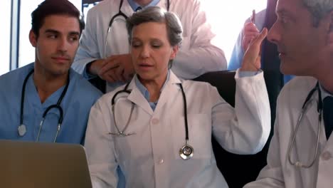 médicos mirando la computadora portátil y discutiendo