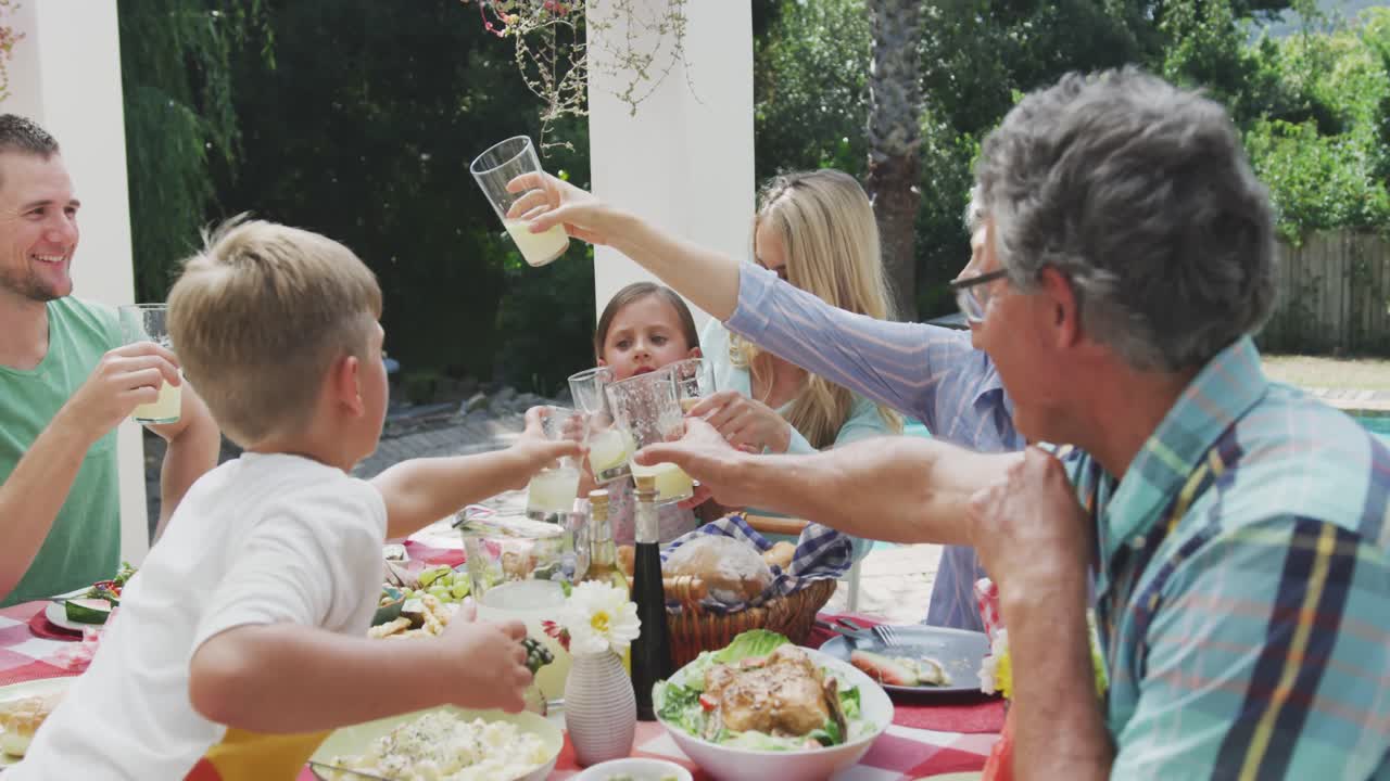 Glad familie spiser sammen ved bordet