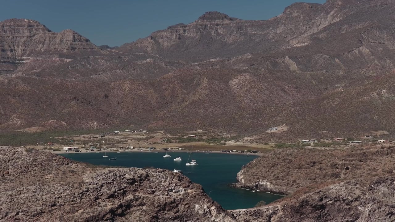 Barche a vela ancorate in una baia riparata sotto le montagne desertiche vicino a La Paz Bassa California scena 7
