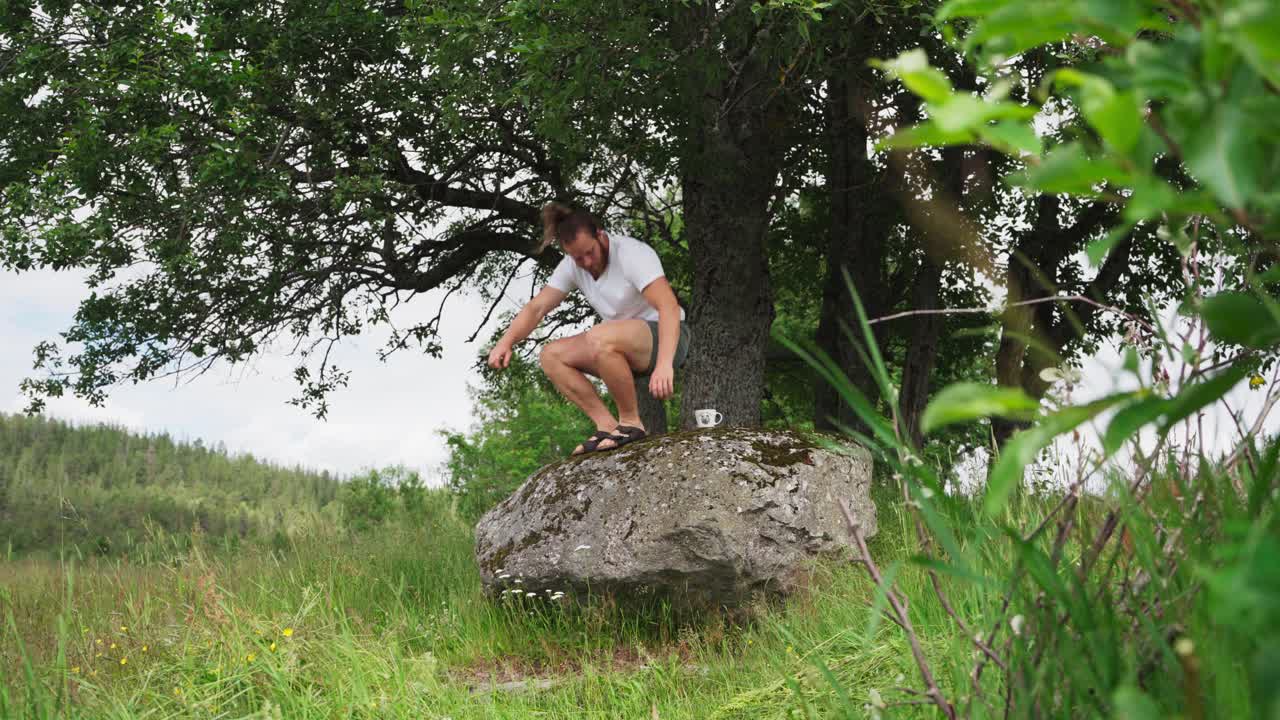 커피 한 잔과 함께 거대한 바위에 앉아 휴식을 취