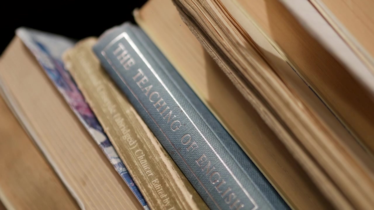 Macro close-up of a hand taking a book from a shelf and putting it back