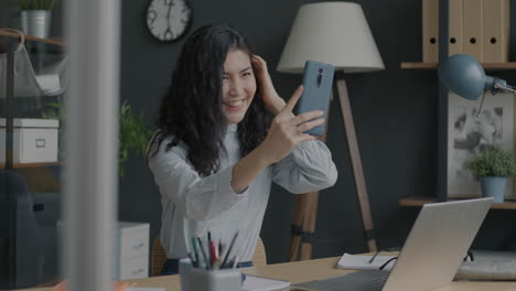 mujer tomando una selfie en la oficina