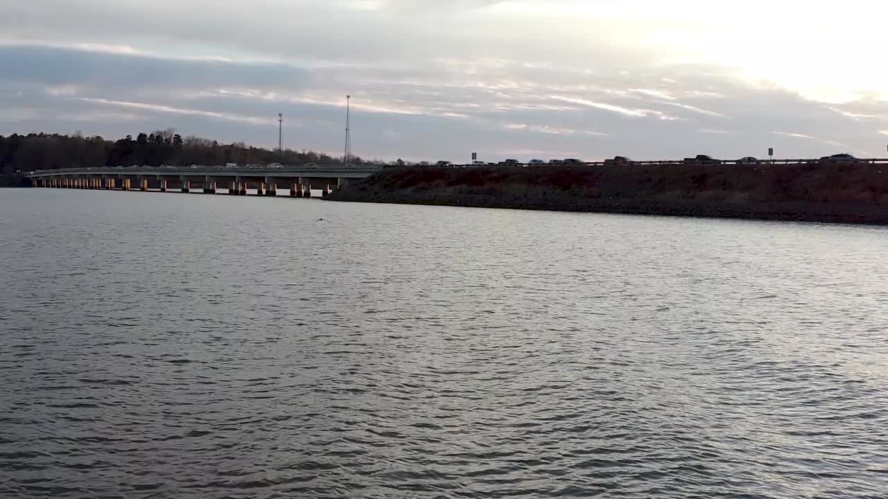 아름다운 날에 호수 건너 일몰 속으로 날아가는 새