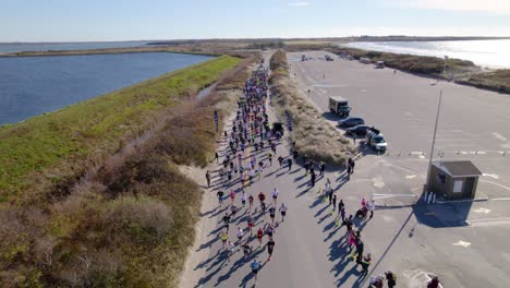 Antenne-Von-Läufern,-Die-An-Einem-Sonnigen-Tag-Ein-Straßenrennen-In-Der-Nähe-Des-Strandes-Laufen